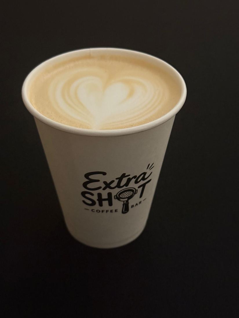 Latte art în formă de inimă într-o cană ExtraShot Coffee Bar